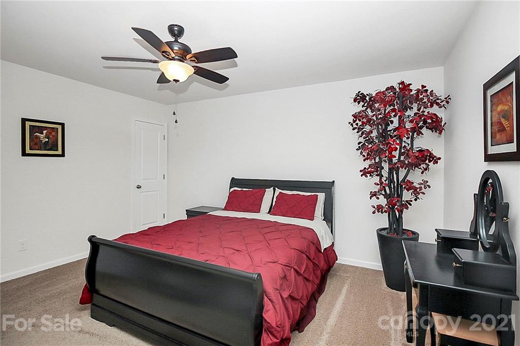 8036 Starnes Randall Road Charlotte, NC 28215 - Photo 23 of 45 a bedroom with a bed dresser and a potted plant