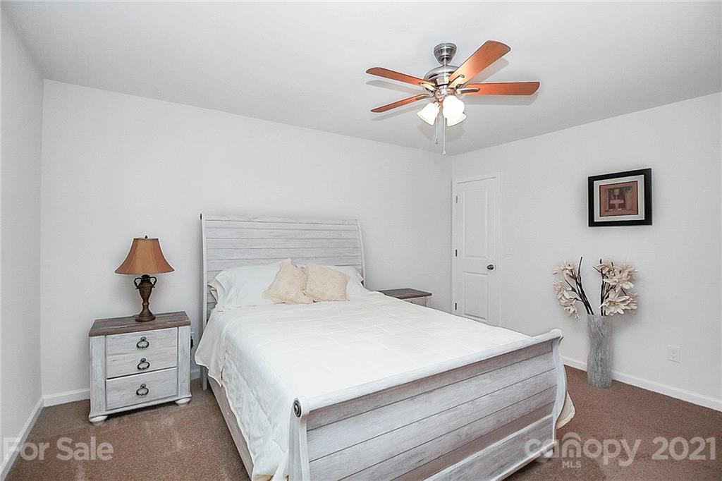8036 Starnes Randall Road Charlotte, NC 28215 - Photo 30 of 45 a bedroom with a bed and a chandelier