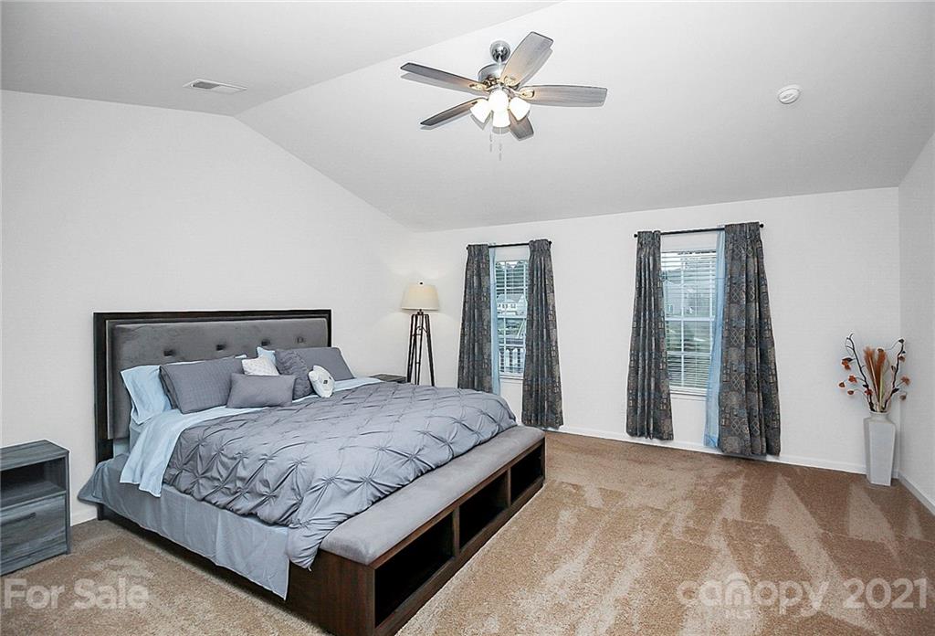 8036 Starnes Randall Road Charlotte, NC 28215 - Photo 32 of 45 a bedroom with a large bed and a chandelier