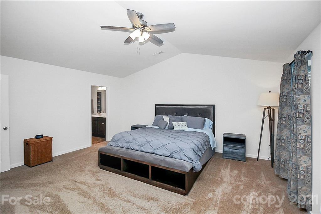 8036 Starnes Randall Road Charlotte, NC 28215 - Photo 33 of 45 a spacious bedroom with a bed and a chandelier