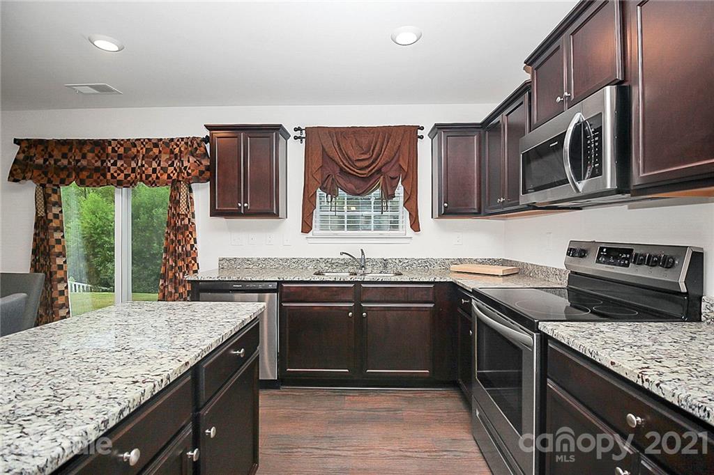 8036 Starnes Randall Road Charlotte, NC 28215 - Photo 10 of 45 a kitchen with stainless steel appliances granite countertop a stove a sink and a microwave