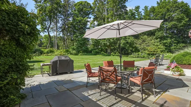 a view of patio with table and chairs under an umbrella