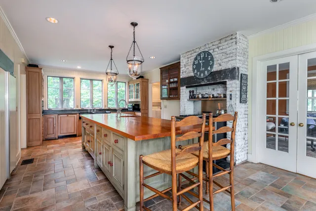 a kitchen with stainless steel appliances kitchen island granite countertop a table chairs and a view of living room