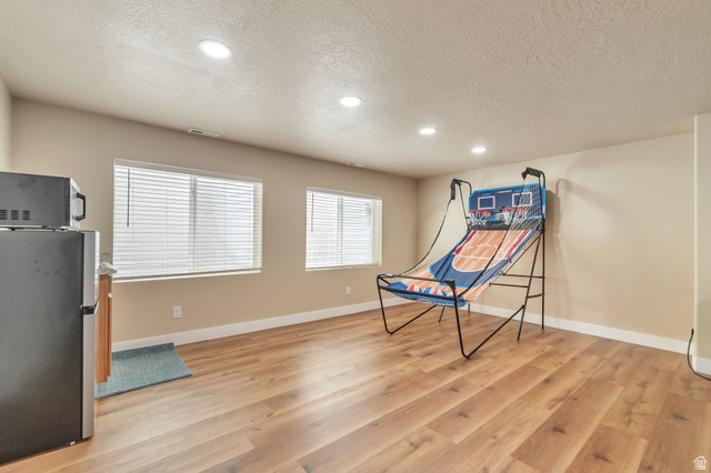13038 Tower Ridge Drive Riverton, UT 84096 - Photo 23 of 30 Spacious room featuring wood-finish flooring, recessed lighting, and two windows with blinds