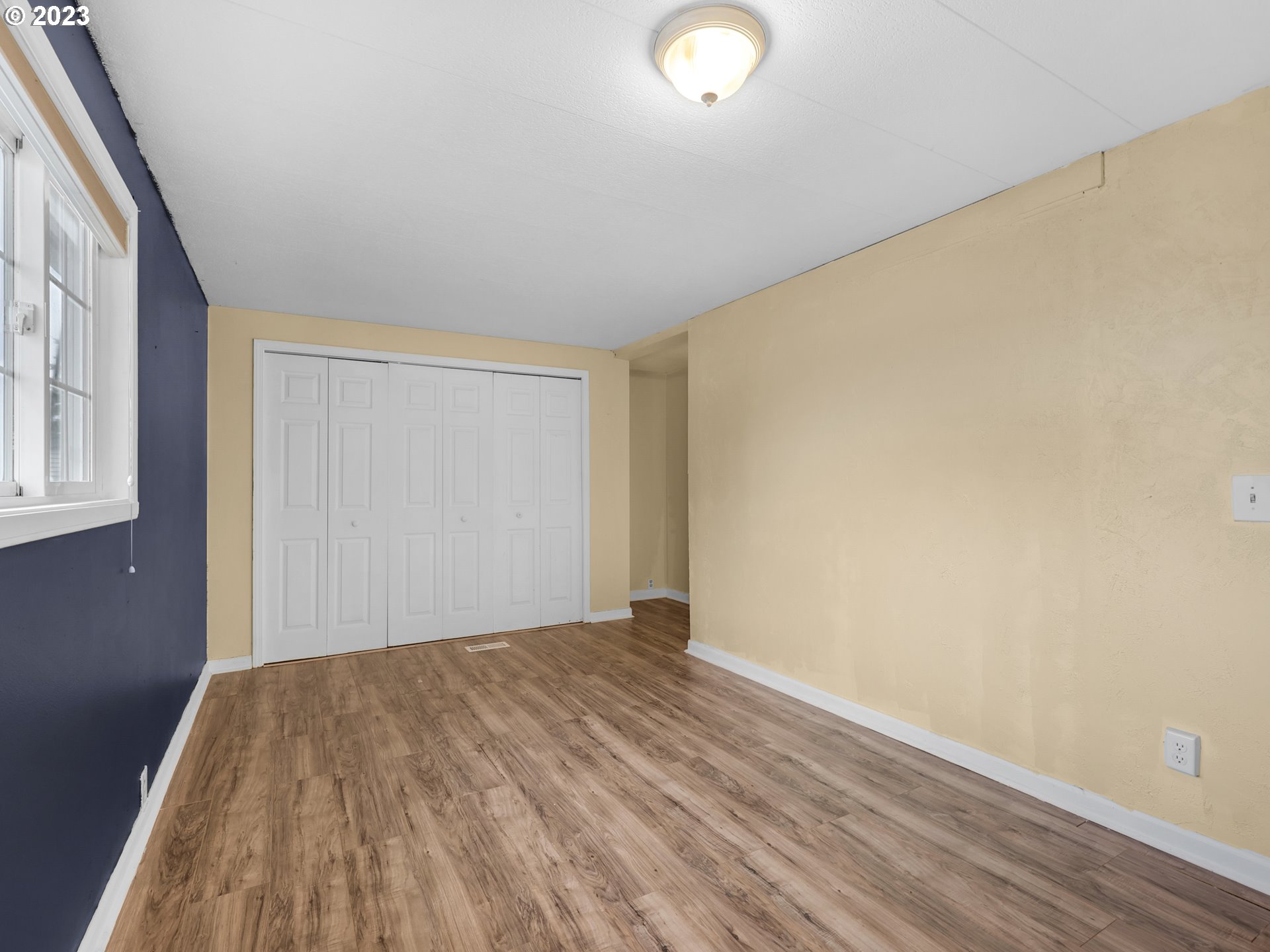 92287 Walluski Loop Astoria, OR 97103 - Photo 14 of 39 an empty room with wooden floor and windows