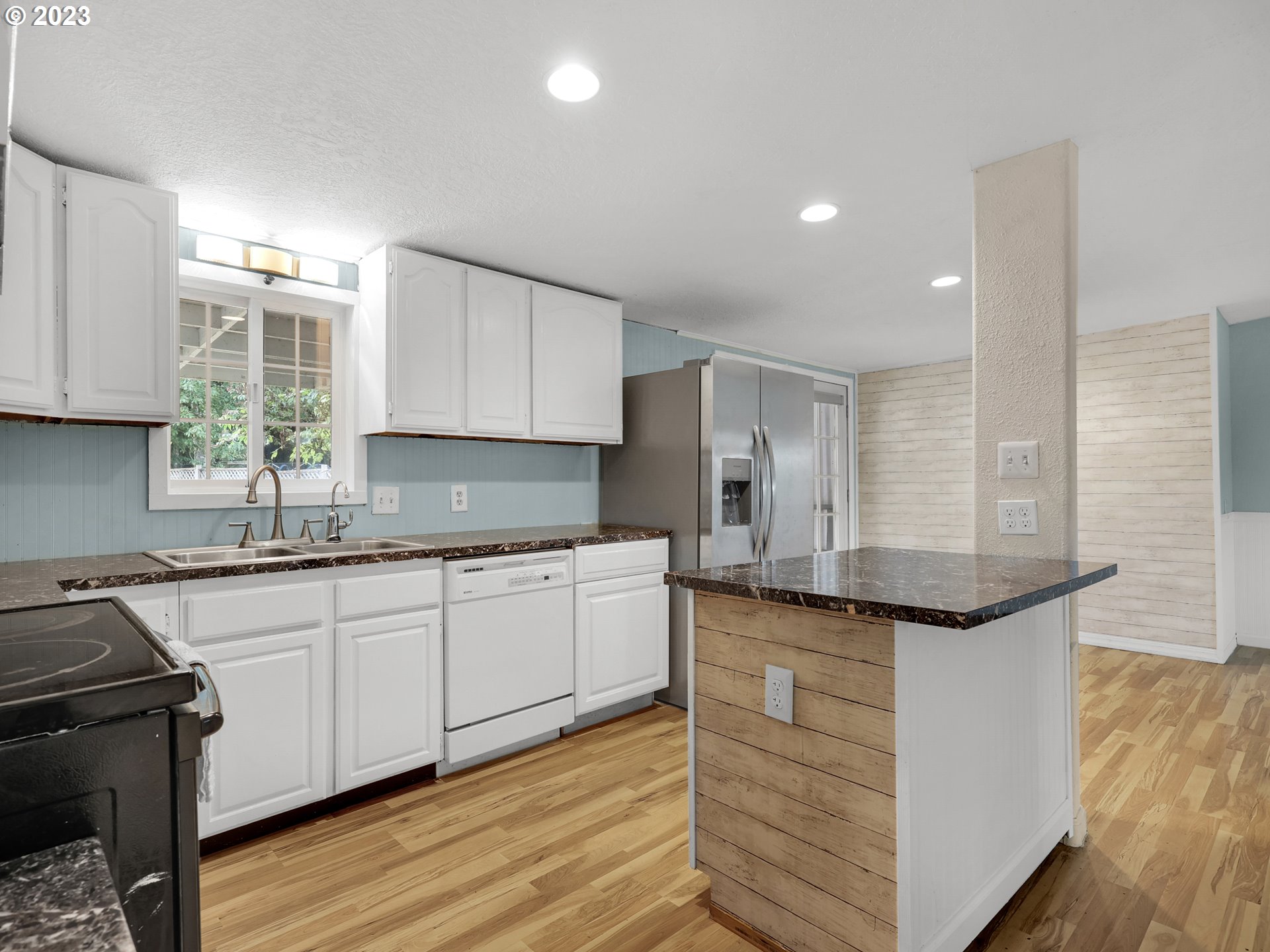 92287 Walluski Loop Astoria, OR 97103 - Photo 3 of 39 a kitchen with granite countertop cabinets stainless steel appliances a sink and wooden floor
