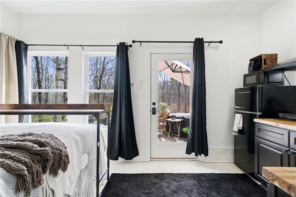 710 Lumber Company Road Talking Rock, GA 30175 - Photo 20 of 27 a bedroom with a bed a flat screen tv and a large window