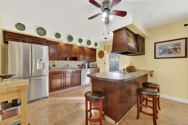 a living room with stainless steel appliances kitchen island granite countertop furniture and a flat screen tv