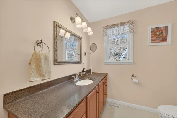 a bathroom with a granite countertop sink and a mirror