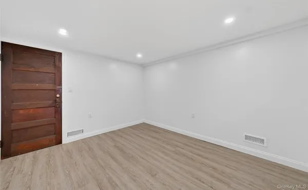 a view of empty room with wooden floor and window