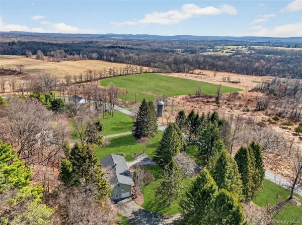 an aerial view of a houses with a yard and lake view