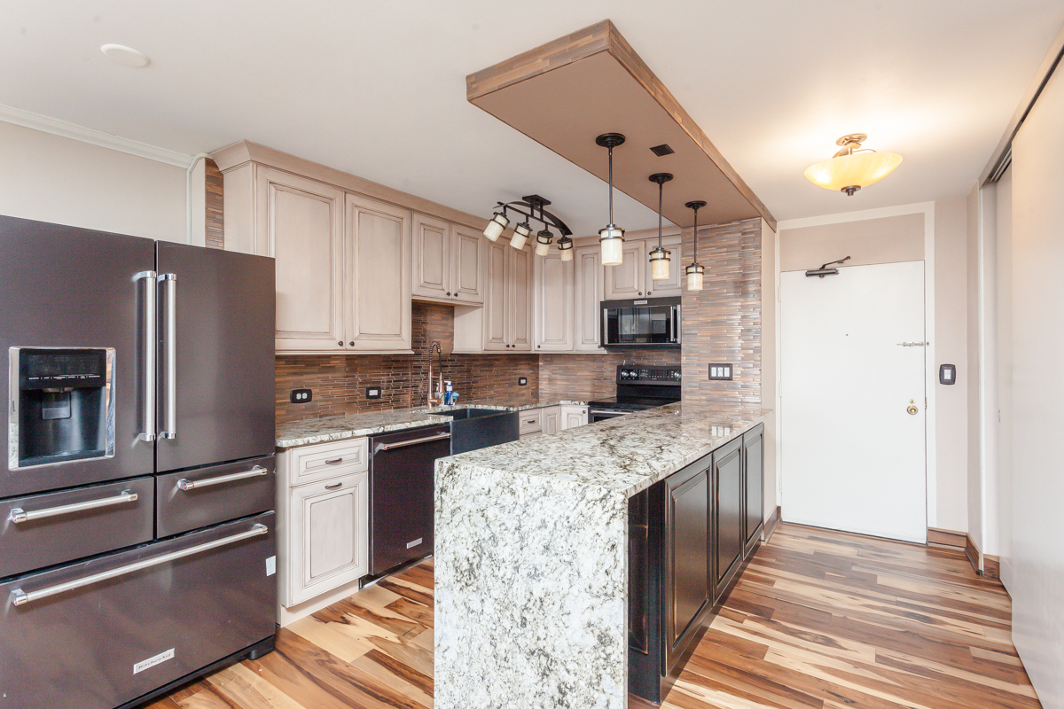 5455 North Sheridan Road, Unit 3307 Chicago, IL 60640 - Photo 3 of 21 a kitchen with stainless steel appliances granite countertop a refrigerator a stove and a sink