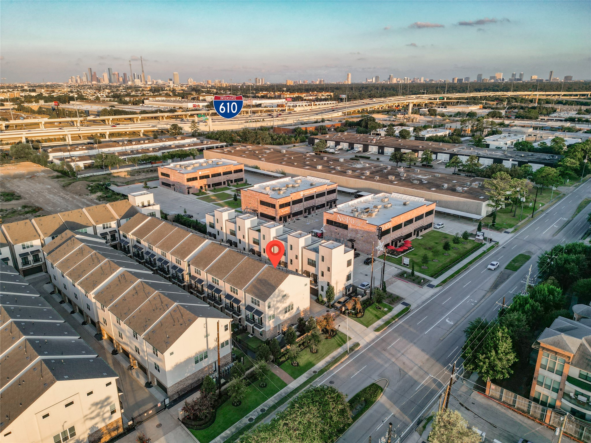 1262 North Post Oak Road, Unit A Houston, TX 77055 - Photo 43 of 50 A high-altitude aerial view pinpoints the property within the development using a location marker. The shot highlights proximity to major roadways, including the Interstate 610 loop and downtown skyline.