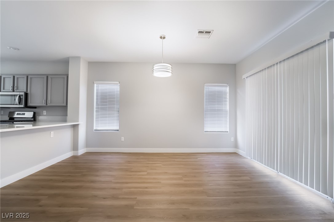 1442 Fieldbrook Street Henderson, NV 89052 - Photo 12 of 36 Unfurnished dining area featuring dark wood-style floors and baseboards