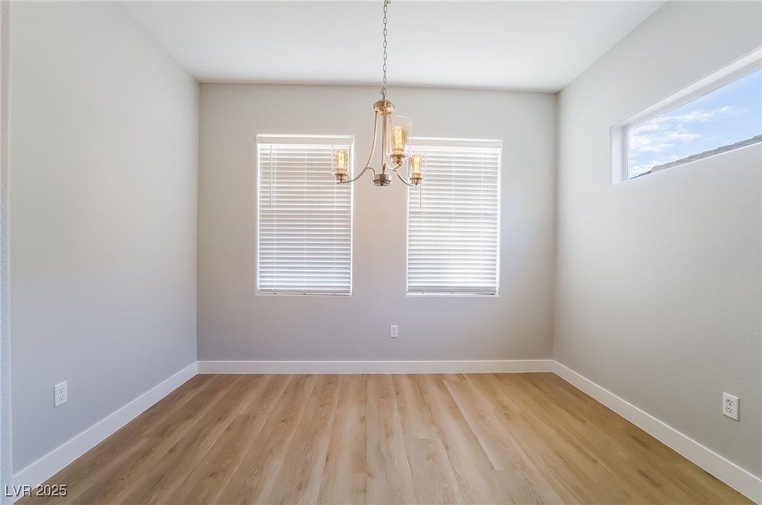 1442 Fieldbrook Street Henderson, NV 89052 - Photo 20 of 36 Spare room with light wood-style flooring and a chandelier