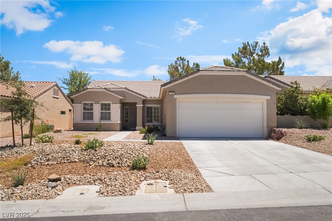 1442 Fieldbrook Street Henderson, NV 89052 - Photo 2 of 36 Ranch-style home featuring stucco siding, a tile roof, concrete driveway, and an attached garage