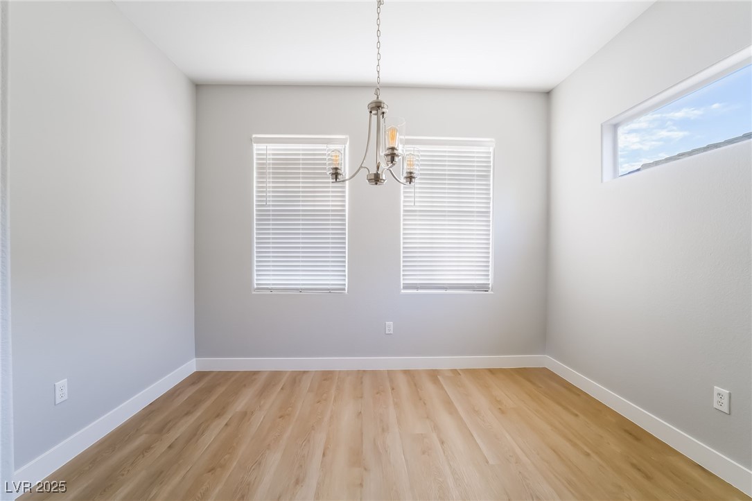 1442 Fieldbrook Street Henderson, NV 89052 - Photo 21 of 36 Empty room featuring light wood-style flooring and a chandelier