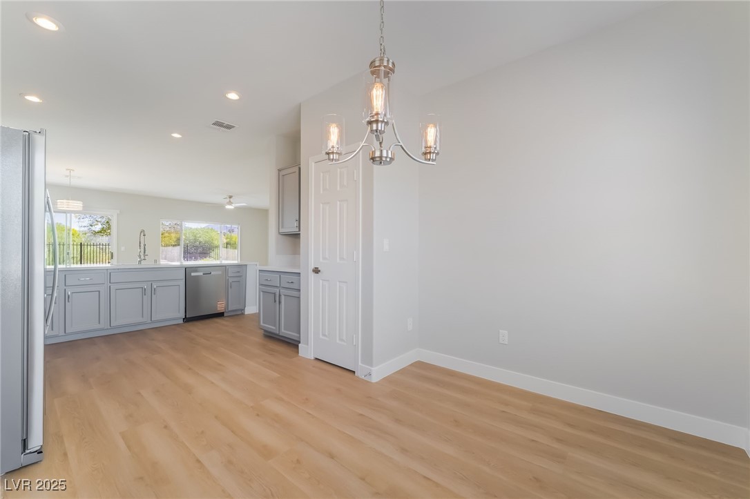 1442 Fieldbrook Street Henderson, NV 89052 - Photo 22 of 36 Kitchen featuring gray cabinets, pendant lighting, appliances with stainless steel finishes, light countertops, and light wood-type flooring