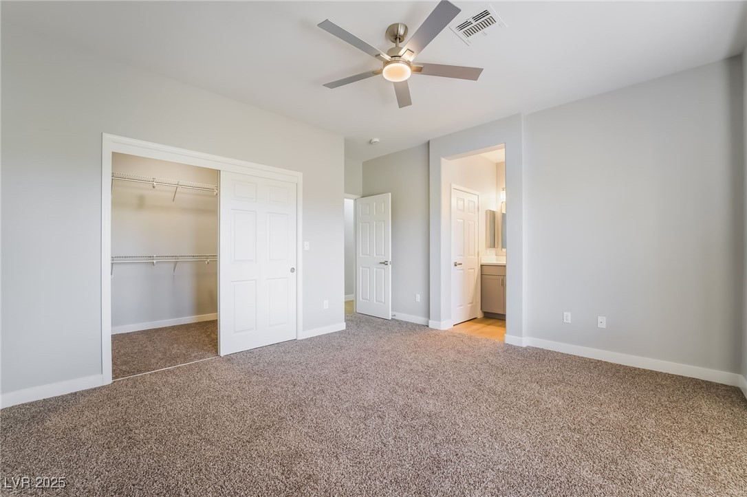 1442 Fieldbrook Street Henderson, NV 89052 - Photo 25 of 36 Unfurnished bedroom featuring light colored carpet, a closet, a ceiling fan, and ensuite bath