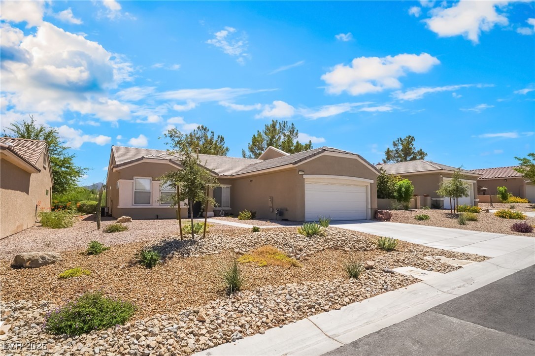 1442 Fieldbrook Street Henderson, NV 89052 - Photo 4 of 36 Ranch-style house with concrete driveway, stucco siding, a garage, and a tiled roof