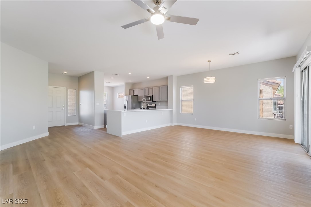 1442 Fieldbrook Street Henderson, NV 89052 - Photo 9 of 36 Unfurnished living room featuring light wood-type flooring, a ceiling fan, and recessed lighting