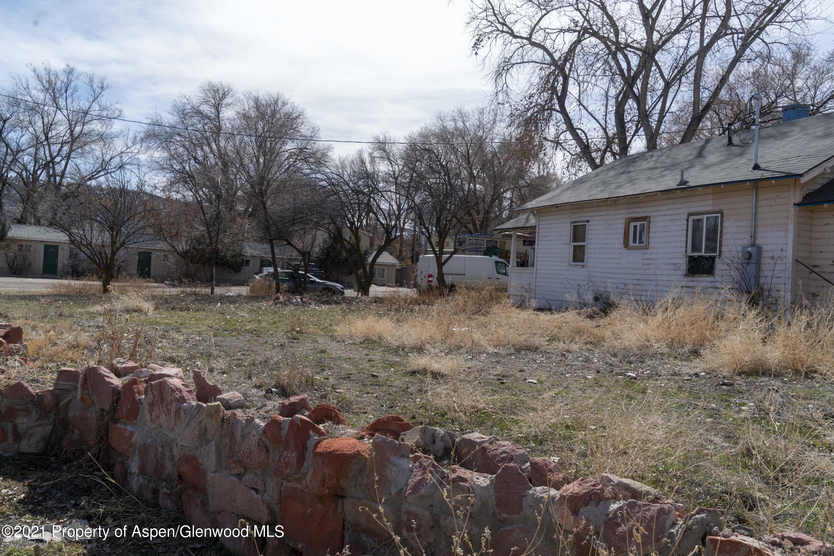 422 West 4th Street Rifle, CO 81650 - Photo 4 of 10 a backyard of a house with large trees and wooden fence