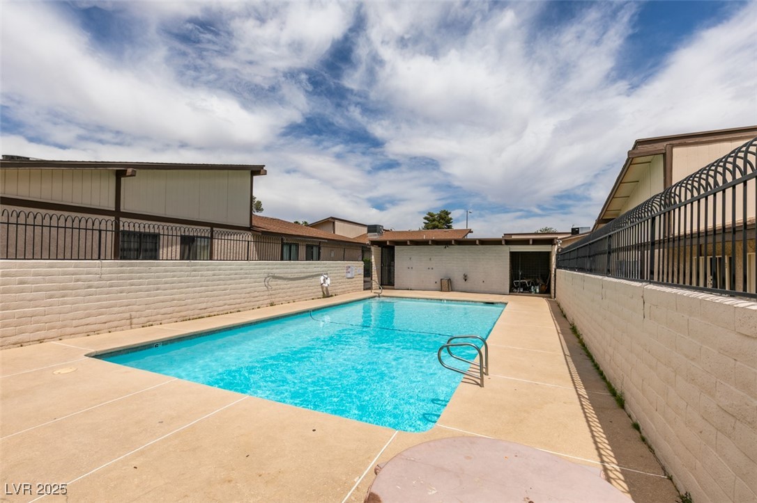 5725 Smoke Ranch Road, Unit A Las Vegas, NV 89108 - Photo 32 of 32 Community pool with a patio and fence