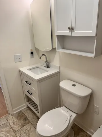 a white toilet sitting next to a bathroom sink