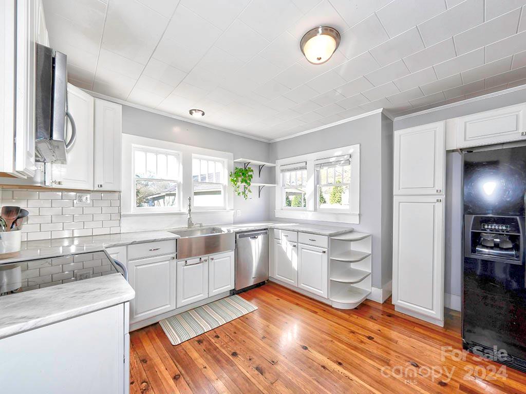 508 South Main Street Troutman, NC 28166 - Photo 11 of 38 a kitchen with stainless steel appliances wooden floors and white cabinets