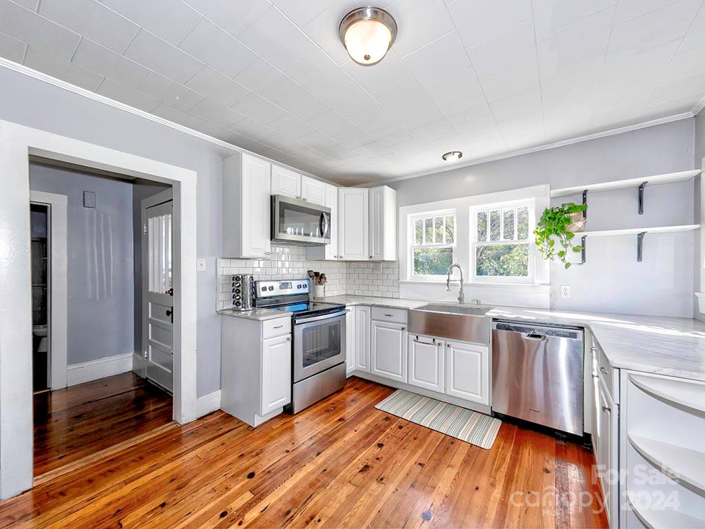 508 South Main Street Troutman, NC 28166 - Photo 10 of 38 a kitchen with a sink wooden floor and stainless steel appliances