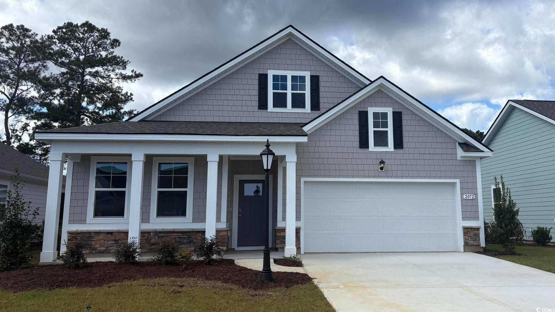 Craftsman house with stone siding, a porch, a shingled roof, concrete driveway, and an attached garage