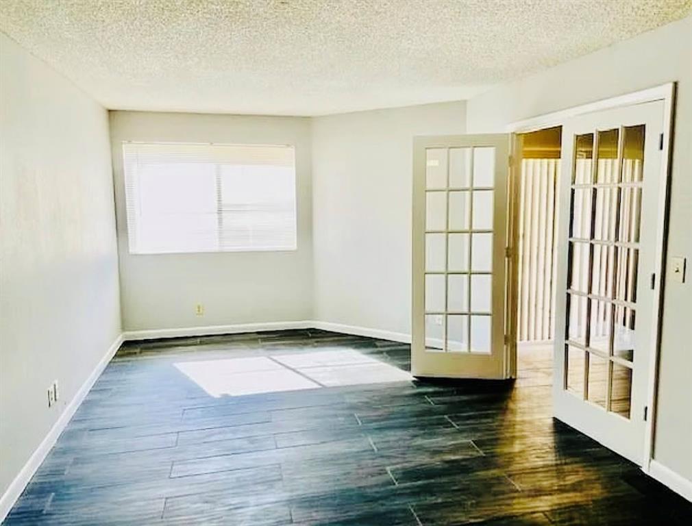 9733 Westview Drive, Unit 1314 Coral Springs, FL 33076 - Photo 4 of 15 an empty room with wooden floor and windows