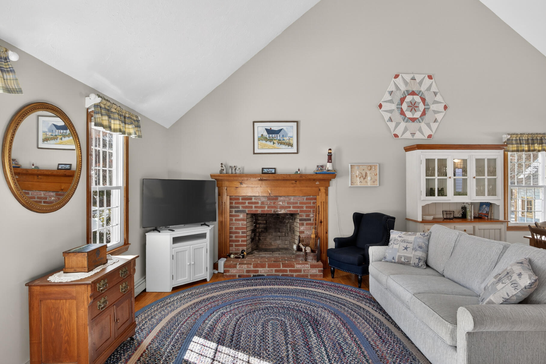 115 Wamsutta Road Eastham, MA 02642 - Photo 4 of 45 a living room with furniture a flat screen tv and a fireplace