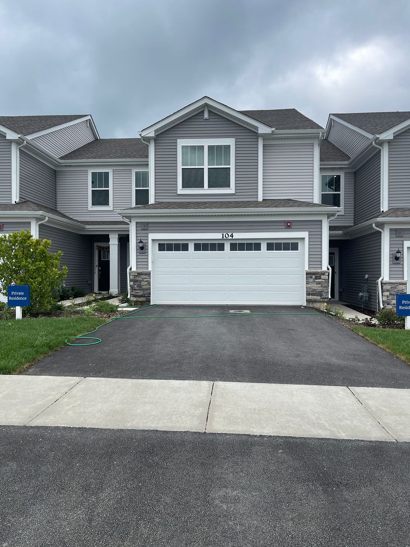 104 Henderson Street Oswego, IL 60543 - Photo 2 of 21 a front view of a house with a yard and a garage