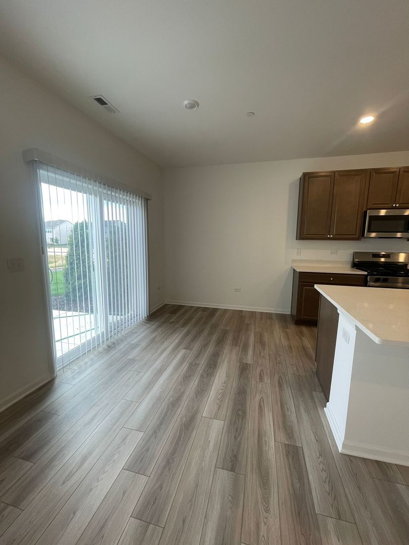 104 Henderson Street Oswego, IL 60543 - Photo 10 of 21 a view of a kitchen with wooden floor and a sink