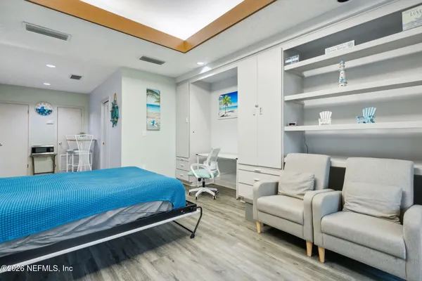 a bedroom with a bed couch and a view of kitchen