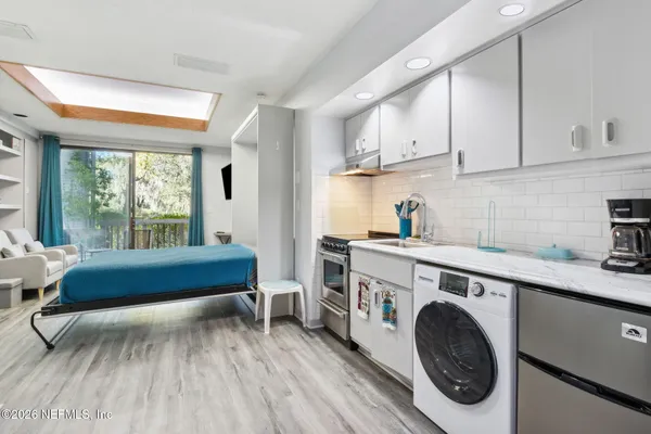 a view of a kitchen with furniture and wooden floor