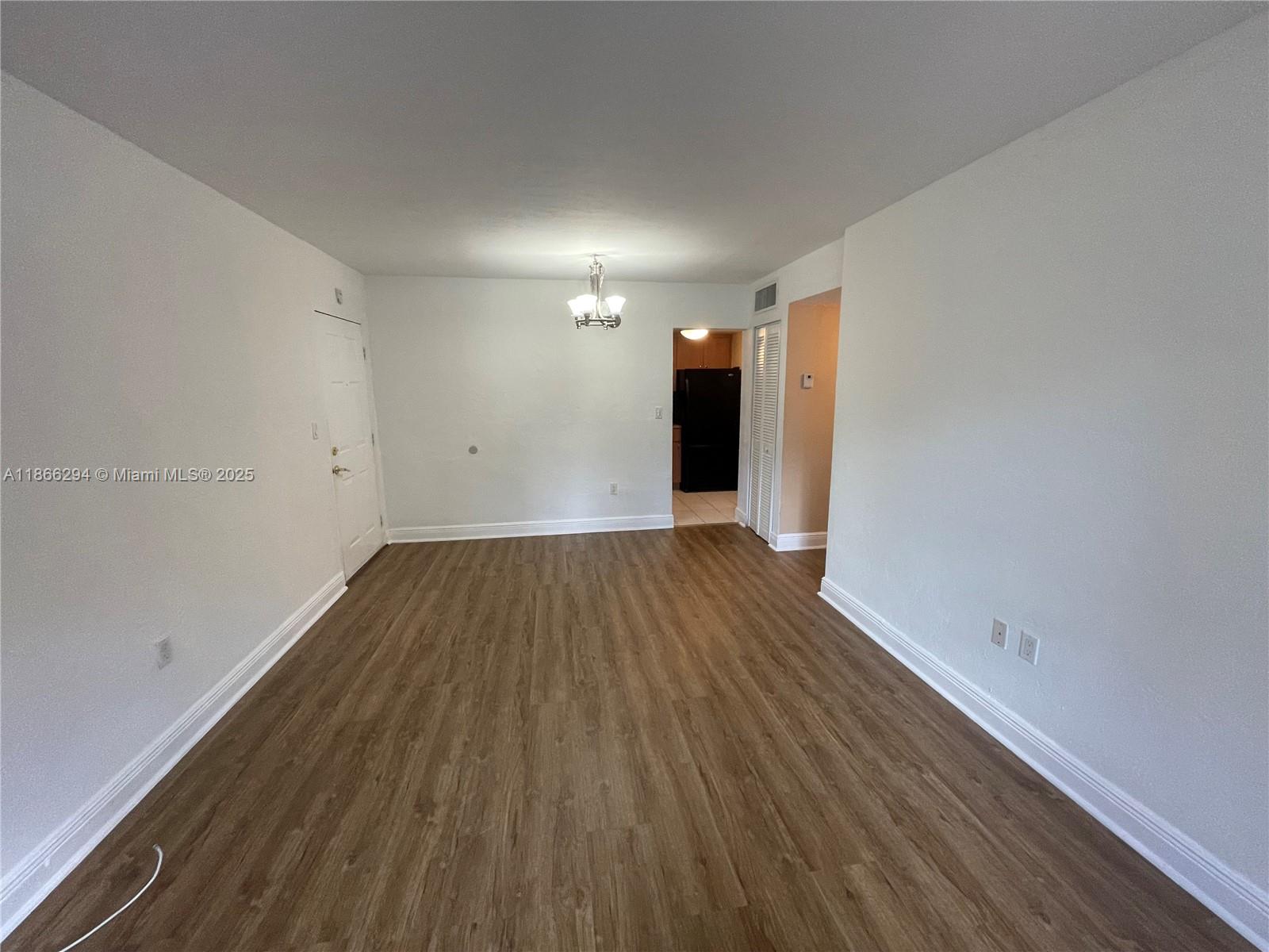 8605 Southwest 68th Court, Unit 1 Pinecrest, FL 33156 - Photo 2 of 20 a view of a room with wooden floors and white walls