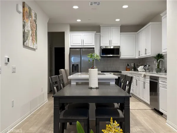 a kitchen with stainless steel appliances kitchen island granite countertop a sink a stove a counter space and cabinets