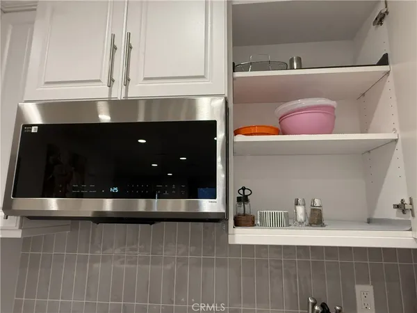 a bedroom with a bed and a flat tv screen next to a window