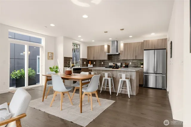 a view of kitchen with refrigerator stove dining table and chairs