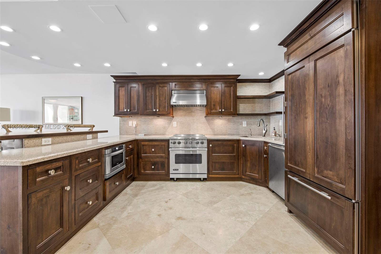 400 North Surf Road, Unit 905 Hollywood, FL 33019 - Photo 12 of 24 a kitchen with stainless steel appliances granite countertop a refrigerator and a stove top oven