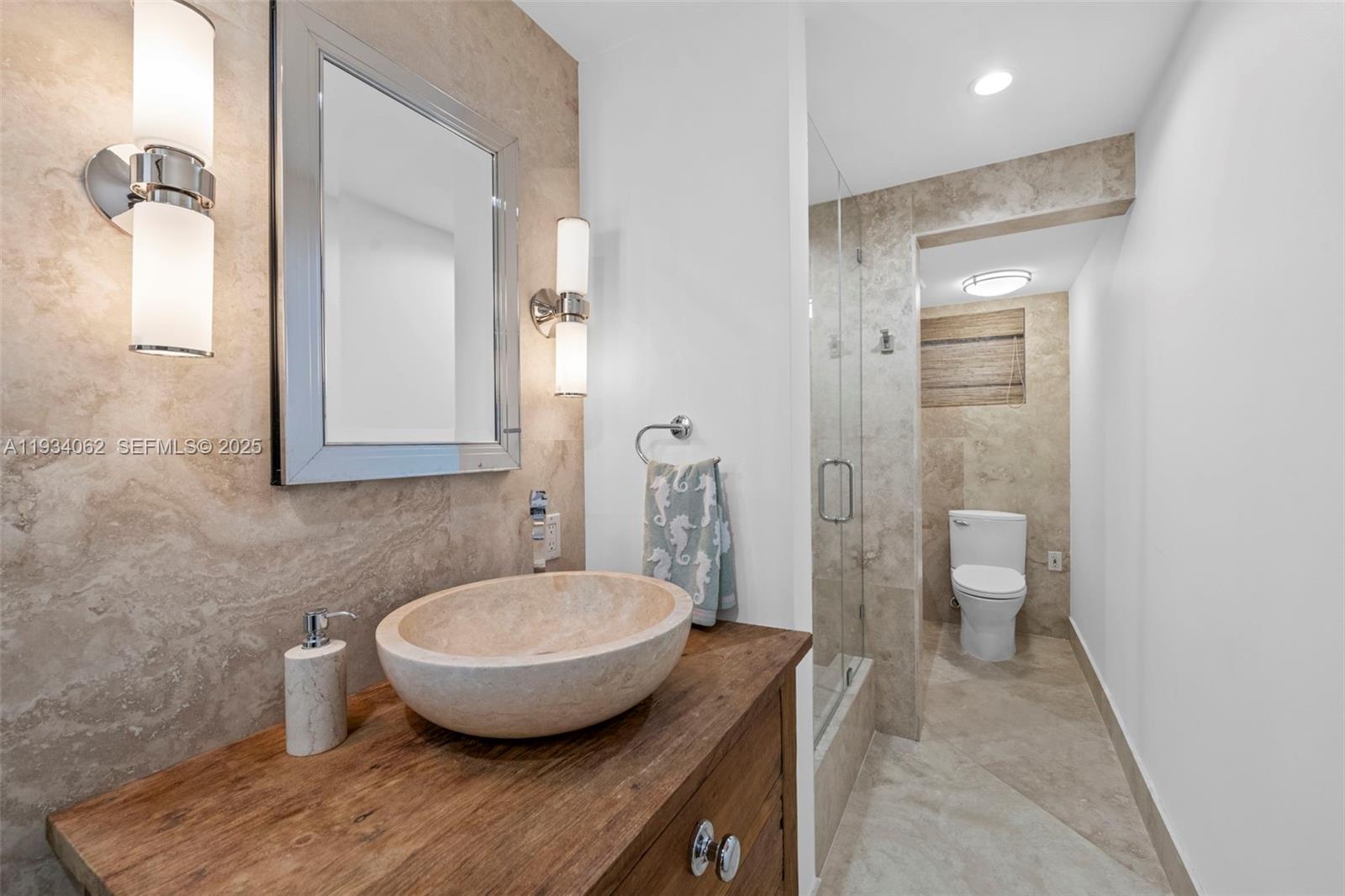 400 North Surf Road, Unit 905 Hollywood, FL 33019 - Photo 21 of 24 a bathroom with a granite countertop toilet a sink and a mirror