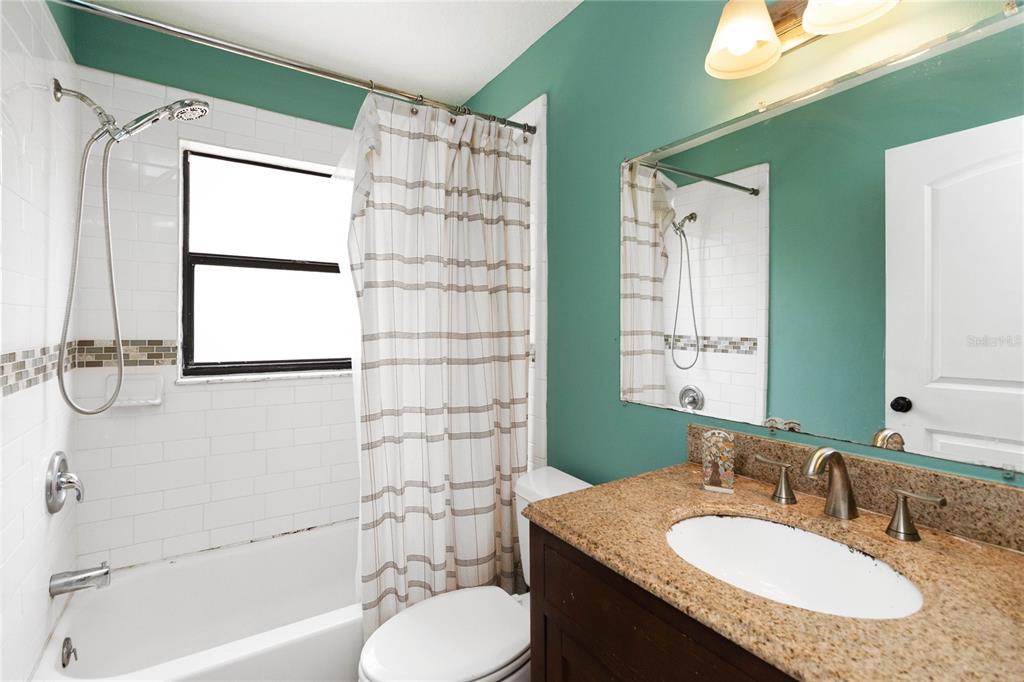 1647 Riveredge Road Oviedo, FL 32766 - Photo 16 of 28 a bathroom with a granite countertop sink toilet a mirror and shower