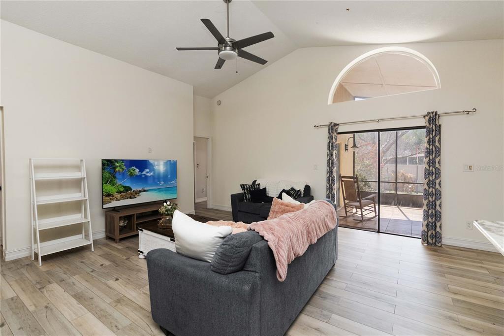 1647 Riveredge Road Oviedo, FL 32766 - Photo 6 of 28 a living room with furniture a flat screen tv and a floor to ceiling window