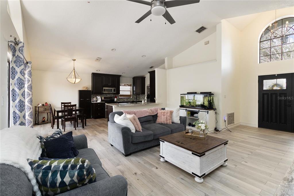1647 Riveredge Road Oviedo, FL 32766 - Photo 7 of 28 a living room with furniture a flat screen tv and kitchen view