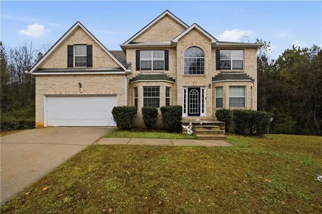 a front view of a house with a yard and garage