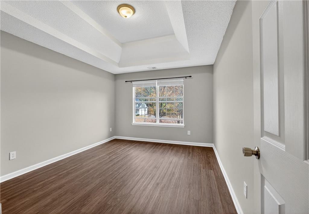336 Riverview Court Fairburn, GA 30213 - Photo 11 of 18 an empty room with wooden floor and windows