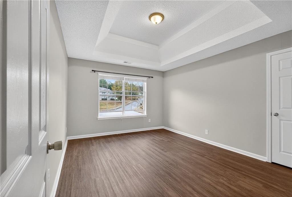 336 Riverview Court Fairburn, GA 30213 - Photo 14 of 18 an empty room with wooden floor and windows