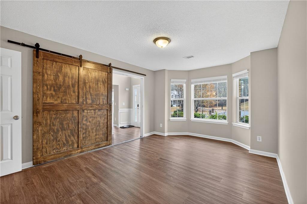 336 Riverview Court Fairburn, GA 30213 - Photo 6 of 18 a view of an empty room with wooden floor and a window